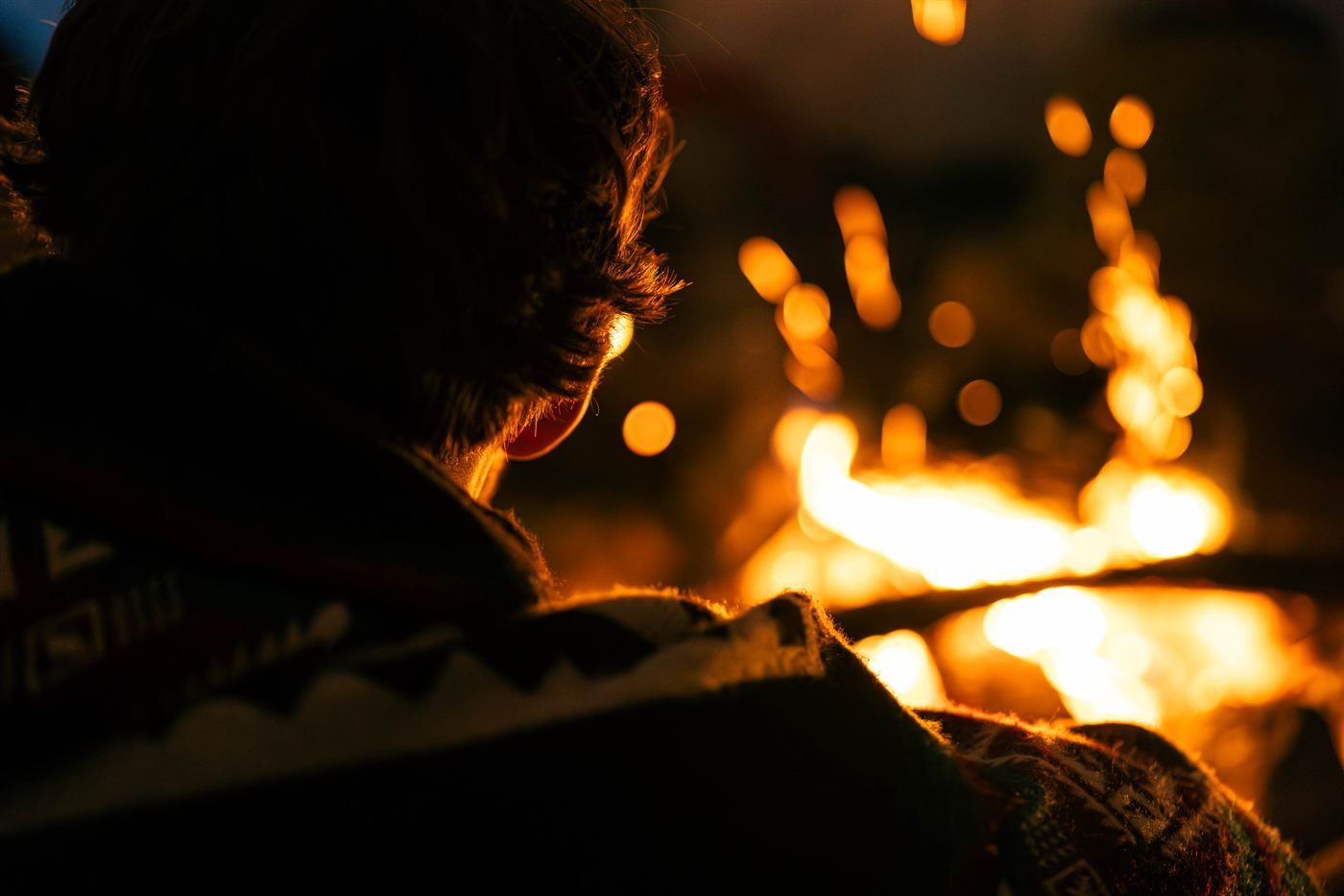 Mensch am Feuer in der Dämmerung